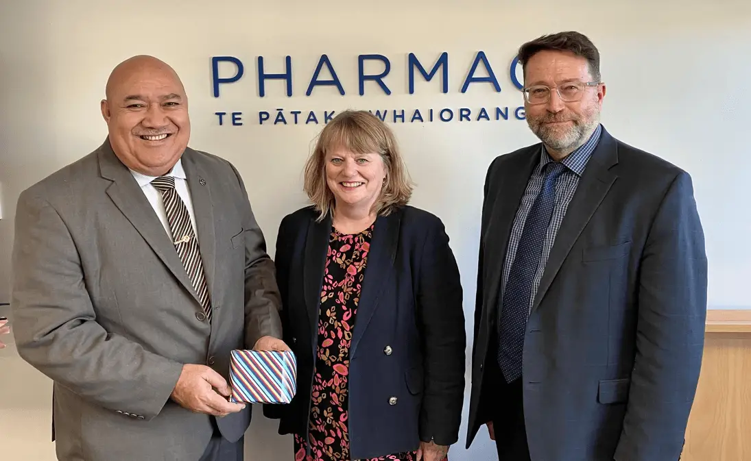 Sarah Fitt, CE of Pharmac, stands between Dr Saia Ma’u Piukala and Dr Mark Jacobs. Dr Piukala holds a small gift..