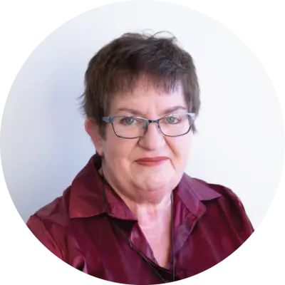 Hazel Heal is an older Pākehā woman. She has short cropped brown hair. She is smiling..
