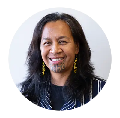 Robyn is a mature Māori woman with a tamoko. Smiling with warm professionalism.