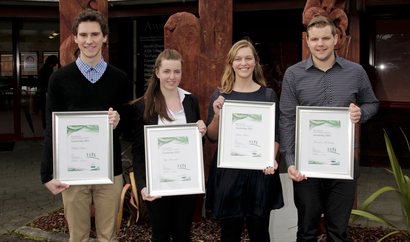 Four scholarship winners displaying their certificates. 